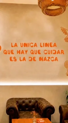 El local de Nazca, con sillones y una pared con figuras de las líneas de Nazca