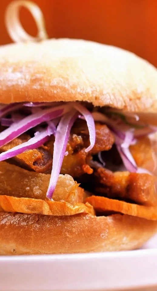 Sánguche de chicharrón con camote y salsa criolla